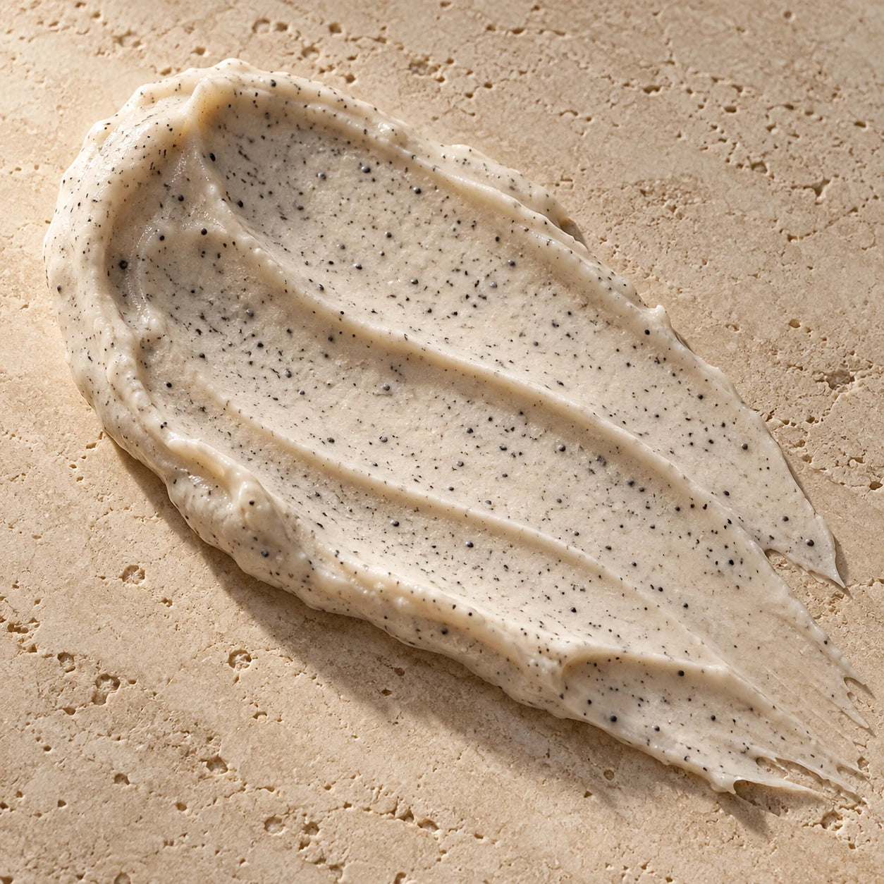 Gros plan de la texture du gommage, avec ses grains sombres